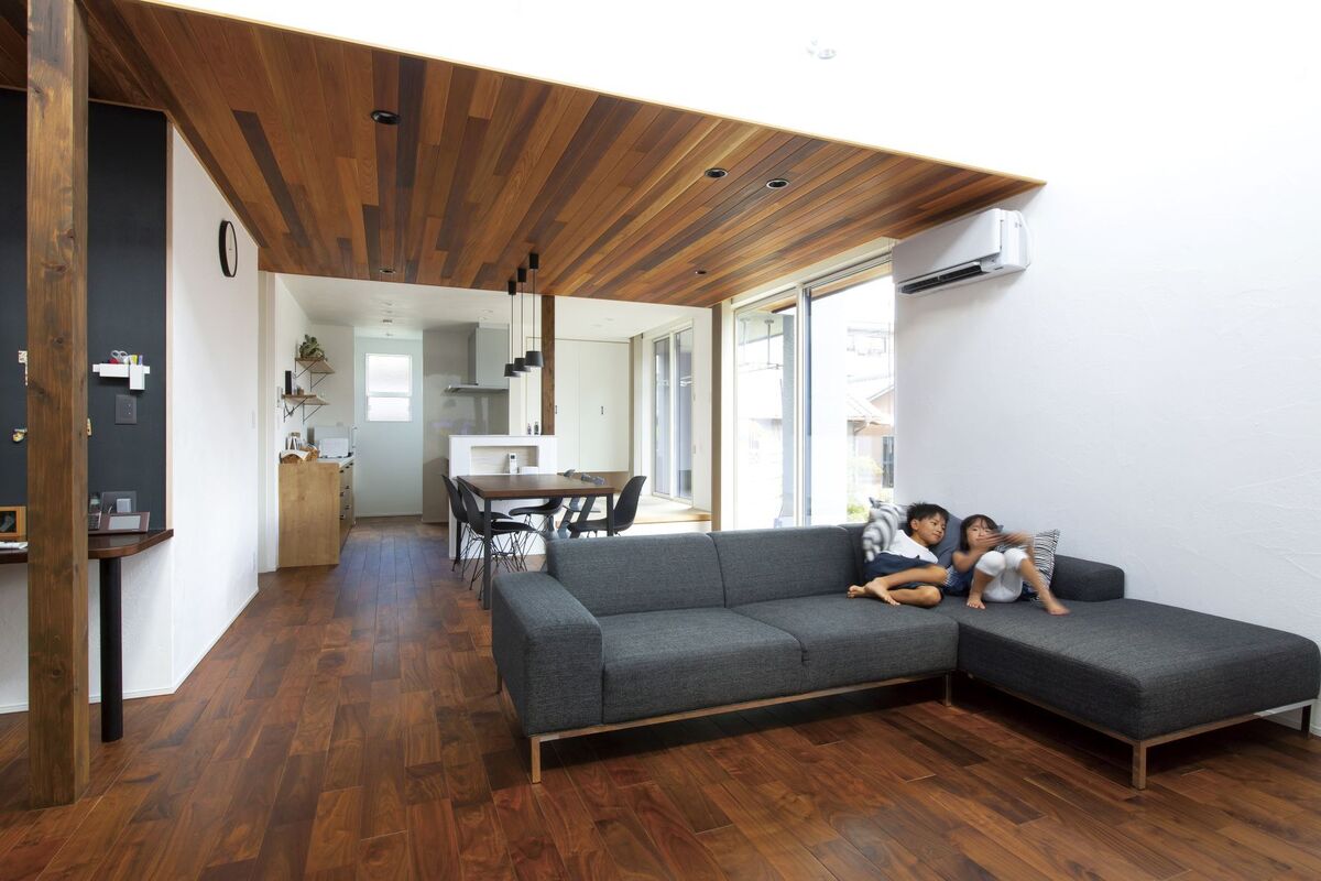 天井や床の木目、家具やアクセントクロスのブラックが空間を引き締めるナチュラルモダンなリビングダイニング