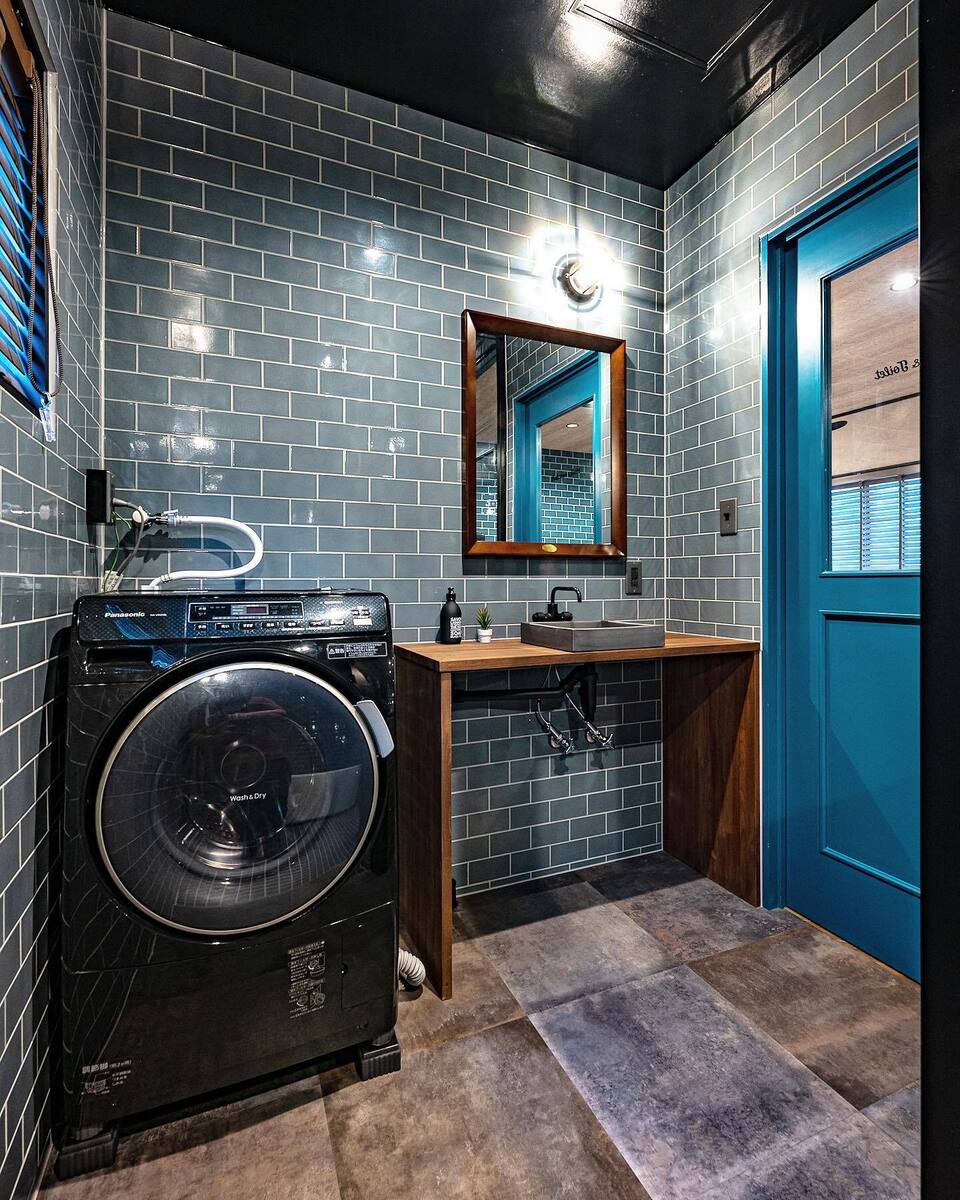 木をアクセントに極力シンプルに造作したオリジナル洗面台で、スモーキーブルーのタイルが映えるスタイリッシュモダンな洗面脱衣室