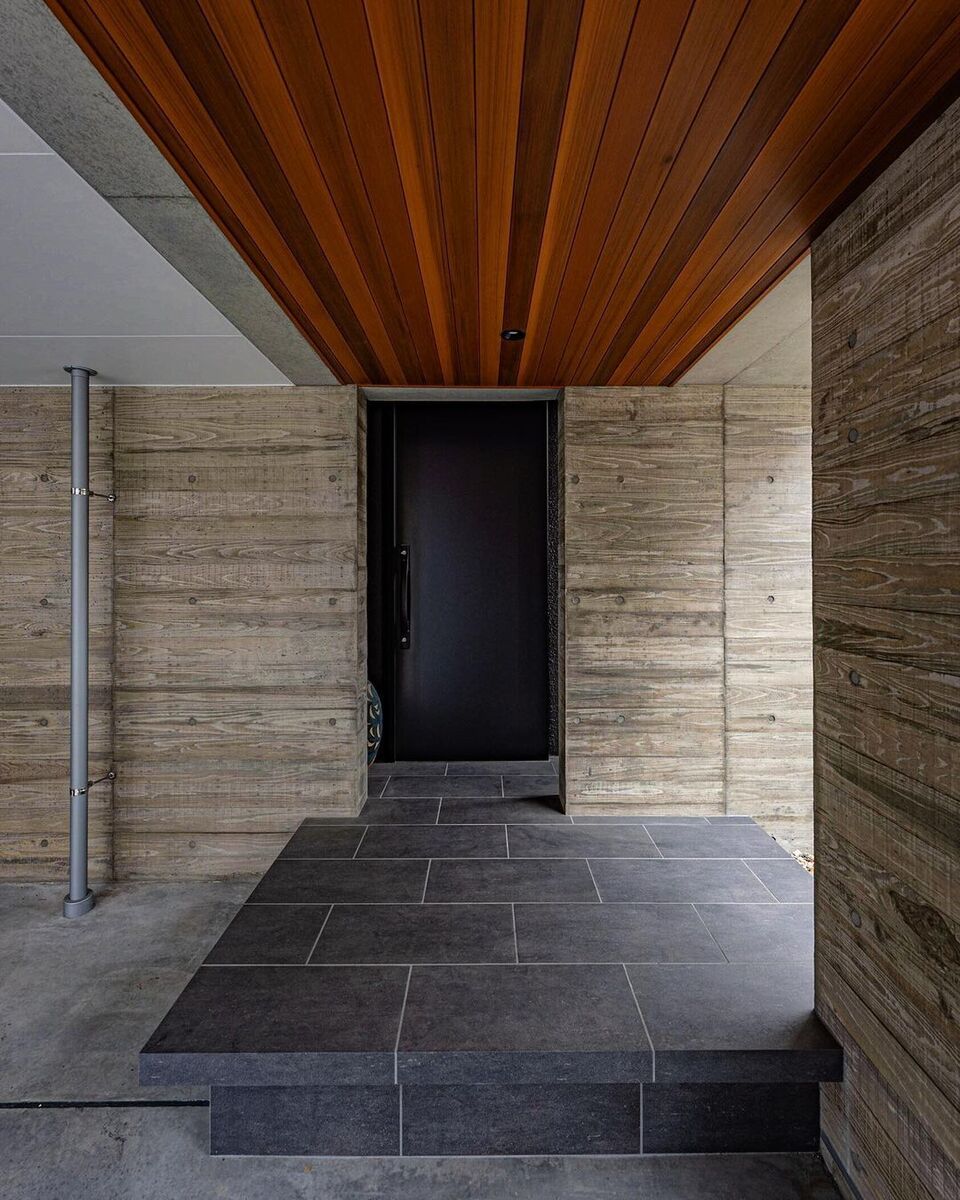 木と石とコンクリートのコントラストが美しいおしゃれな空間はガレージから玄関へ続くアプローチ