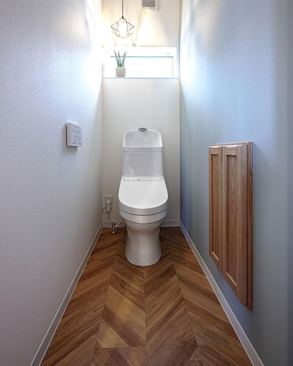 ヘリンボーン柄の床にブルーグレーのアクセントクロス、アイアンの可愛いペンダントライトでトイレもおしゃれな空間に！