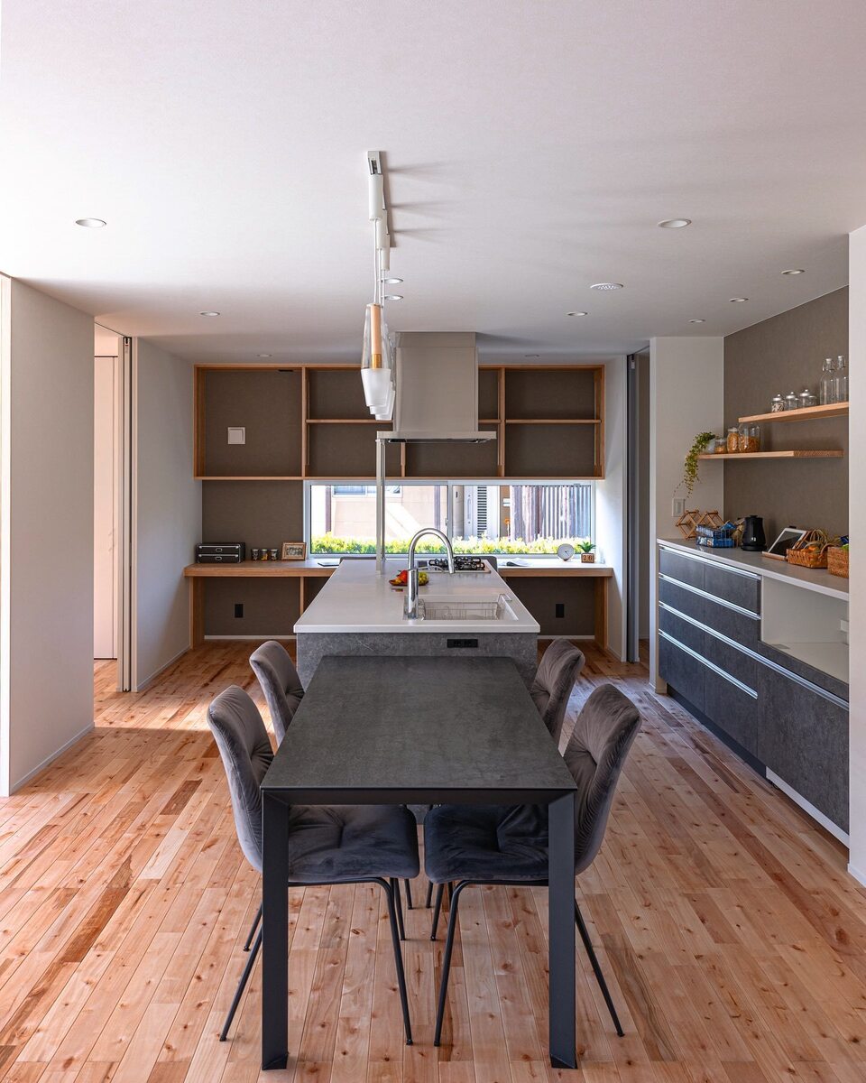 白×木目　のナチュラルな空間にグレーのキッチン＆カップボードを加えてモダンなダイニングキッチン。奥にはアクセントクロスにカウンターと見せる収納棚を造作して機能的かつおしゃれな壁面に！