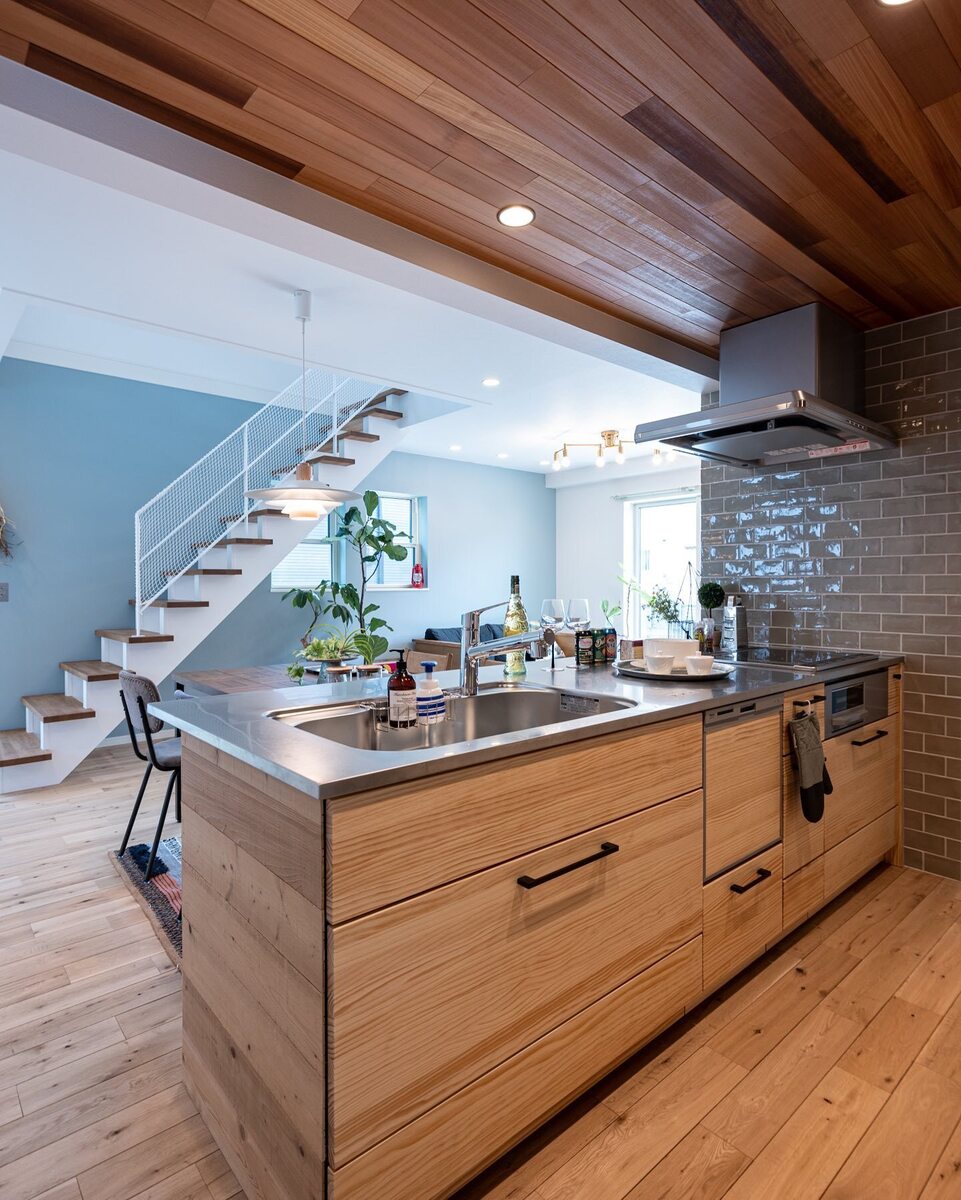 オープンスタイルキッチンに、フローリングや天井も木目が映えるナチュラルなキッチンに、コンロ横に貼ったグレーのサブウェイタイルがおしゃれなアクセントに！