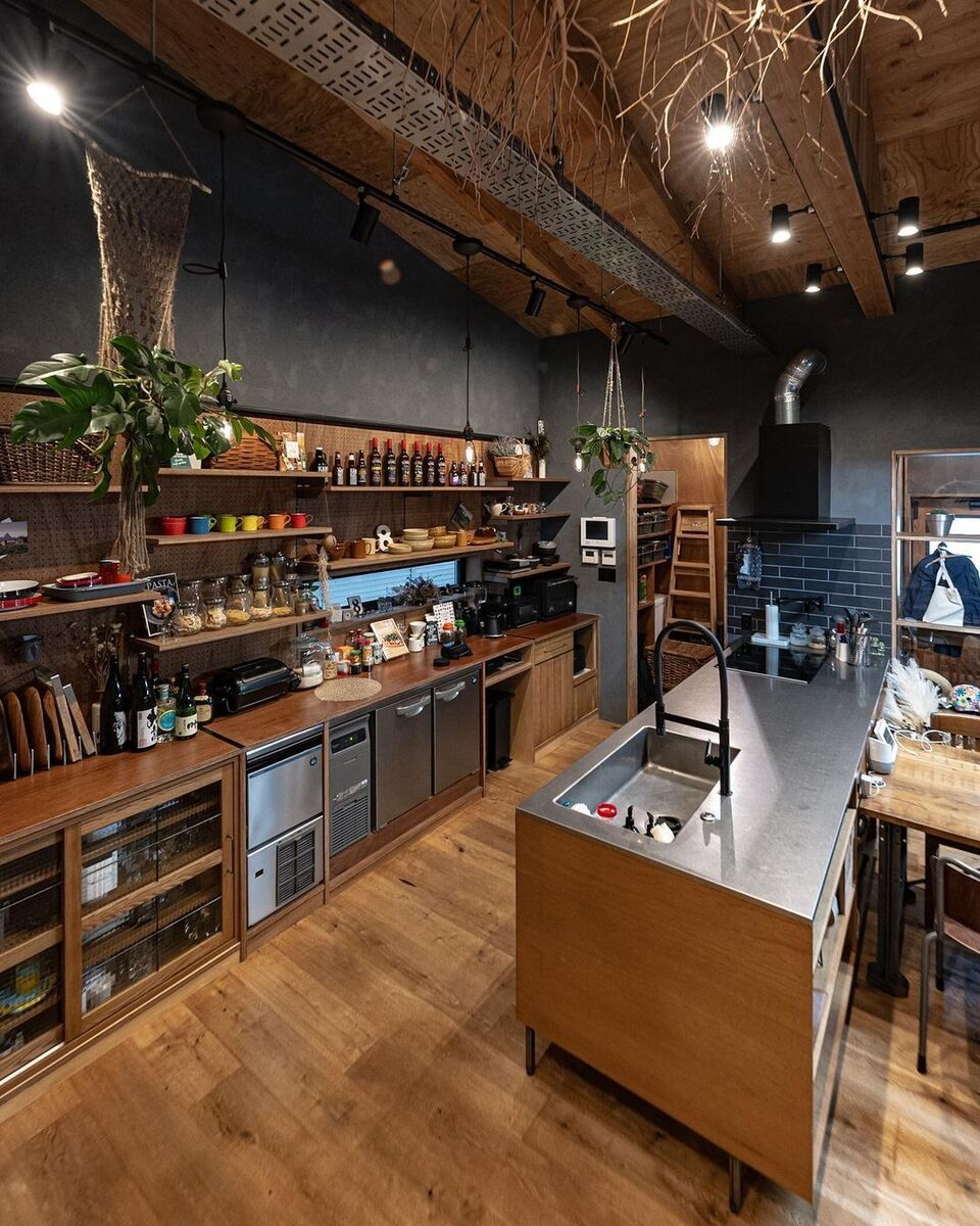 フローリングや天井、キッチンの木目に合わせた壁面の木製造作収納は、既製品のガラス戸棚や業務用製氷機、作業台と冷蔵庫を兼ねた「コールドテーブル」をはめ込んでスッキリシンデレラフィット⟡細長い窓も設けてしっかり明かり取りも！