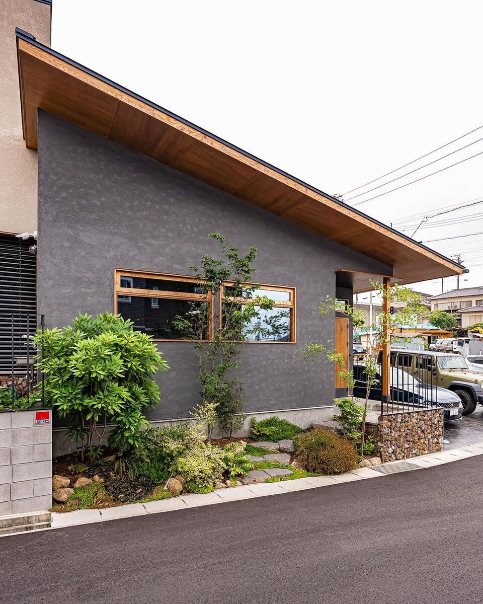 軒天の木目が美しく片流れ屋根がスタイリッシュな外観の家。シックなグレーの外壁は、左官仕上げの塗り壁にすることで、温かみのある質感が生まれています。