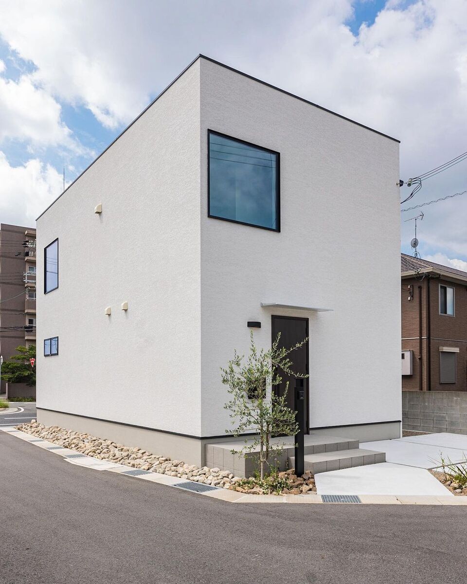 白くてキューブ型、総二階のコンパクトながらシンプルでスタイリッシュな家。成長が楽しみな敷地角のシンボルツリーは、外観にアクセントを加えつつ、道路と敷地を緩やかに区切っています。