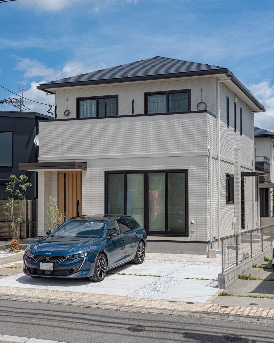 ベージュの外壁をブラックの屋根や窓枠で引き締めたシンプルモダンな外観の家。ナチュラルブラウンの木目調玄関ドアも外壁の色にマッチして、飽きの来ない落ち着いたイメージに！