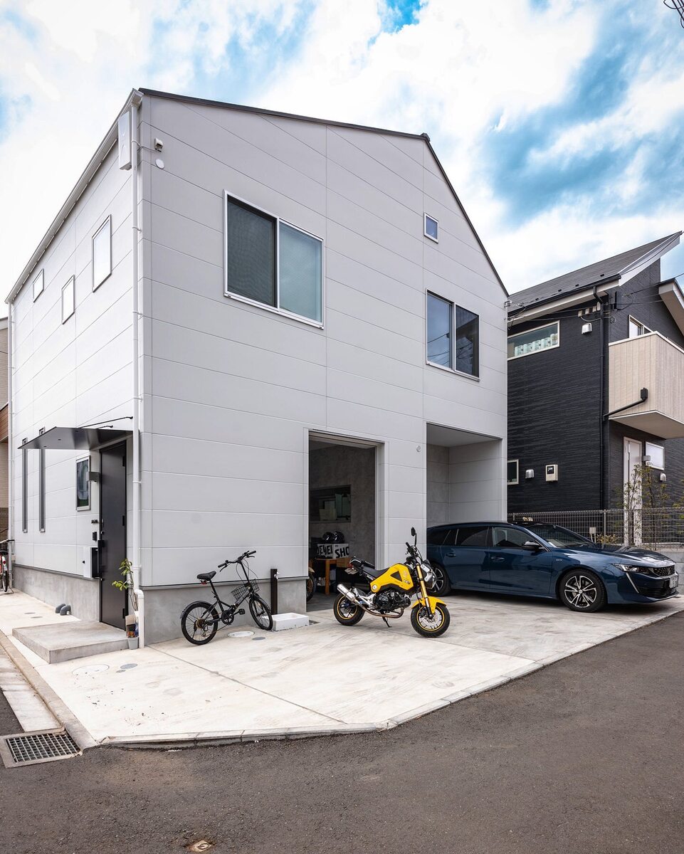 三角の切妻屋根と白い外壁のシンプルフォルムがおしゃれなデザインの家。駐車スペース2台の他、ご主人の愛車を並べるバイクガレージを設けた、お気に入りのガレージハウスです♪